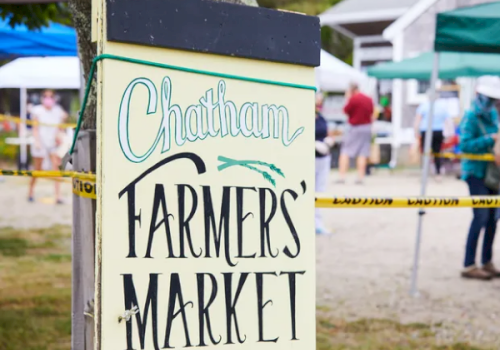 A sign at a market reads &ldquo;Chatham Farmers&rsquo; Market&rdquo; in large teal and black letters.
